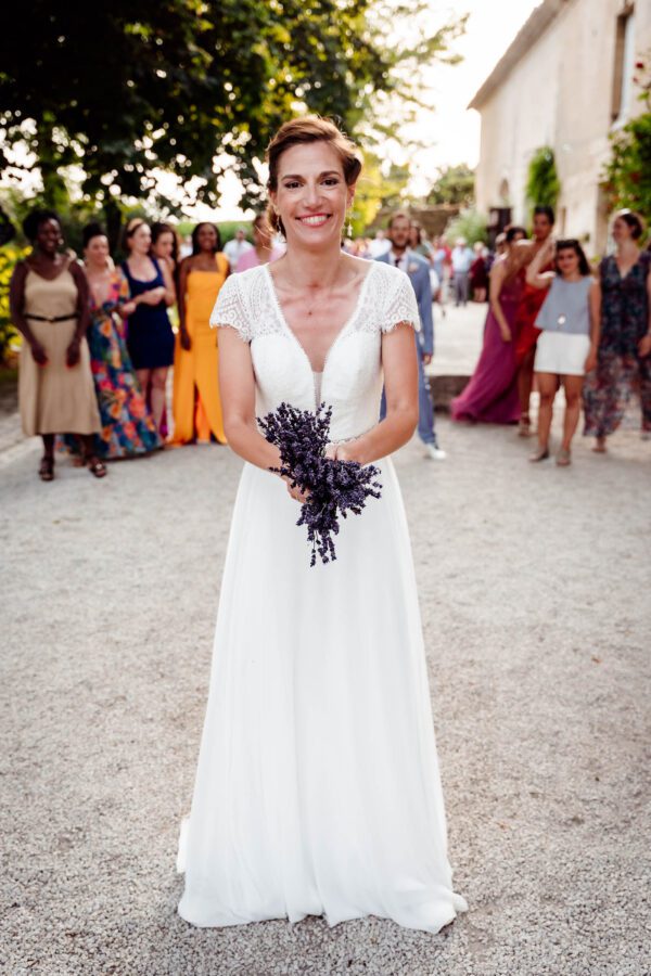 Mariée souriante prête à lancer son bouquet de lavande – mariage en Occitanie