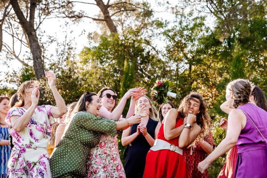 Des femmes éclatent de rire en tentant d’attraper un bouquet lancé dans un jardin du sud de la France