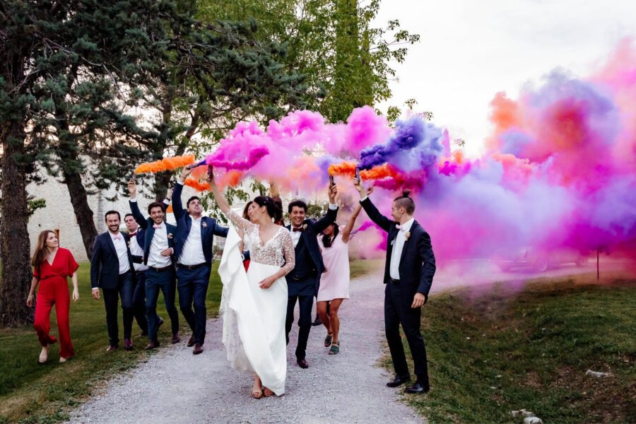 Groupe d invités s amusant avec des fumigènes colorés en extérieur